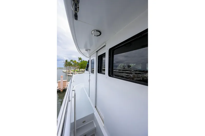 Slide: The Image of Side view of 2003 Cheoy Lee Trideck yacht docked near palm trees. - 63