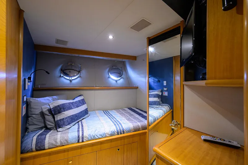 Slide: The Image of Cozy cabin interior of 2003 Cheoy Lee Trideck yacht with striped bedding and porthole windows. - 80