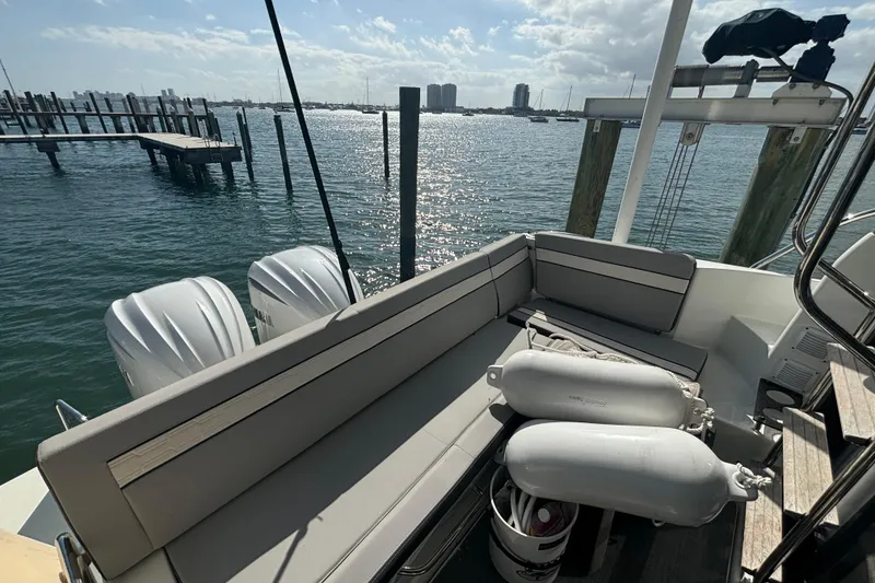 Slide: The Image of 2024 Jeanneau NC Weekender 1095 Fly, rear seating area with ocean view and twin engines. - 11