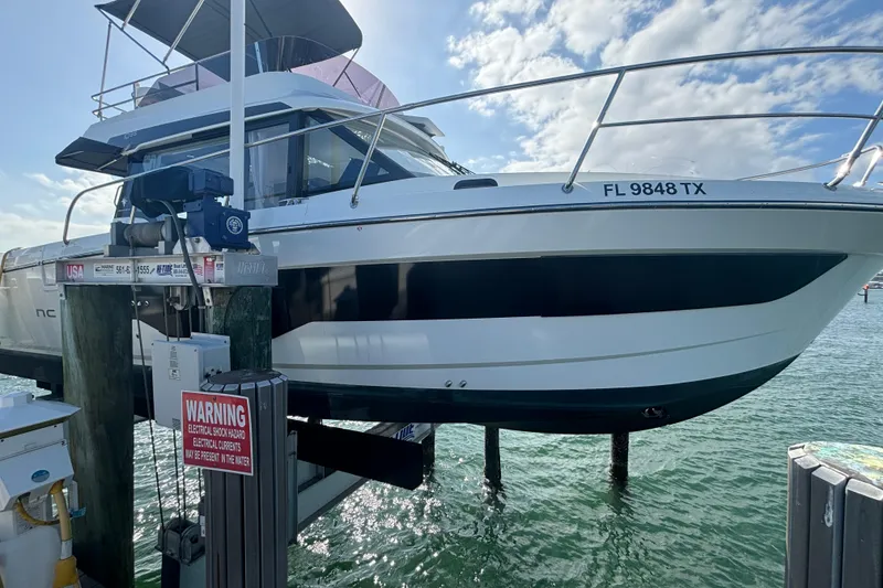 Slide: The Image of 2024 Jeanneau NC Weekender 1095 Fly boat docked, side view with clear sky. - 3