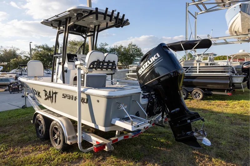 Slide: The Image of 2024 Sea Pro 210 Bay boat with Suzuki outboard motor on trailer, parked outdoors. - 3