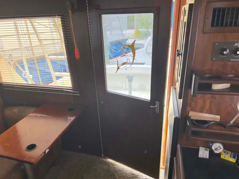 Slide: The Image of Interior of a 1975 Hatteras 36 Convertible boat with wooden furnishings and a window view. - 11