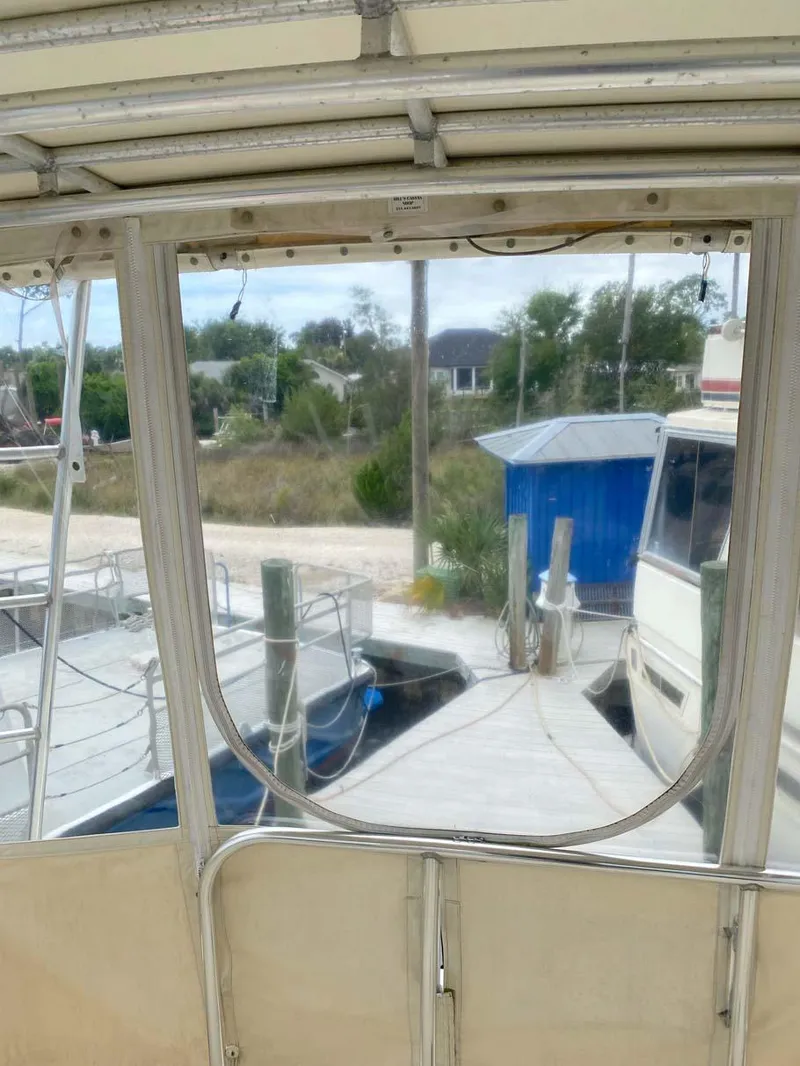 Slide: The Image of 1975 Hatteras 36 Convertible boat docked at a marina with surrounding landscape. - 39