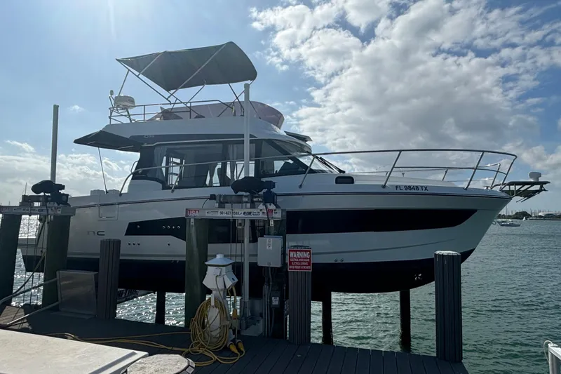 The Image of 2024 Jeanneau NC Weekender 1095 Fly yacht docked under a sunny sky. - 1
