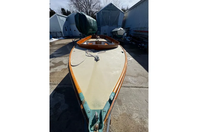 Slide: The Image of 2018 Ballentine's Boat Shop Doughdish sailboat in a boatyard, showcasing deck and wooden trim. - 15