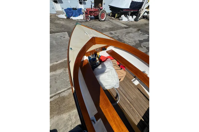 Slide: The Image of 2018 Ballentine's Boat Shop Doughdish sailboat with wooden interior, docked outdoors. - 16