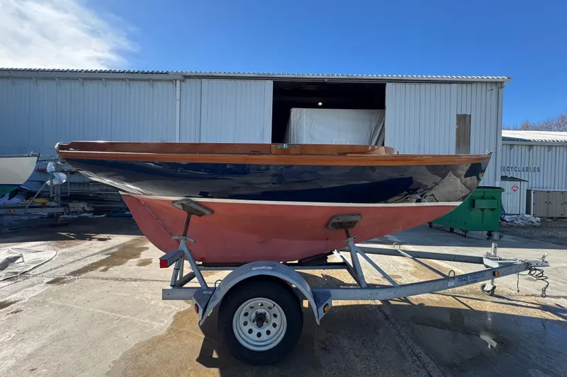 Slide: The Image of 2018 Ballentine's Boat Shop Doughdish sailboat on trailer outside a warehouse. - 18
