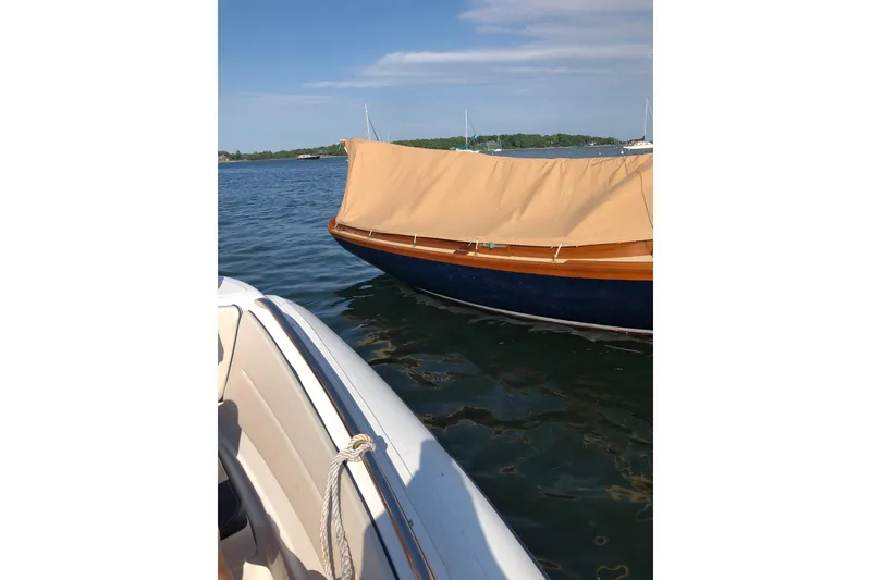 Slide: The Image of 2018 Ballentine's Boat Shop Doughdish sailboat with cover on calm water. - 23