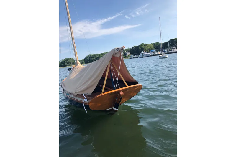 Slide: The Image of 2018 Ballentine's Boat Shop Doughdish sailboat with cover on calm water. - 24