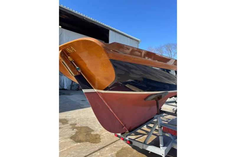 Slide: The Image of 2018 Ballentine's Boat Shop Doughdish sailboat on trailer, showcasing polished wooden hull. - 9