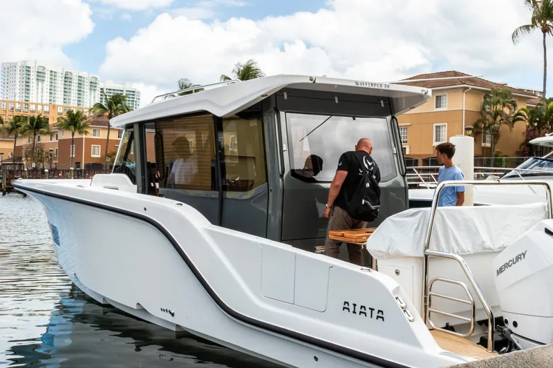 Slide: The Image of Aiata Wayfinder 38 Cabin 2026 docked with people boarding. - 1