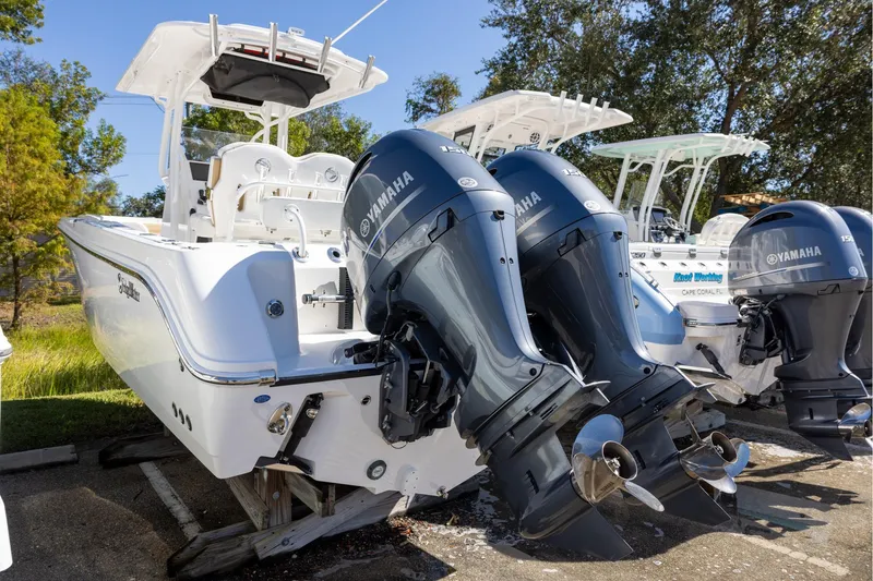 Slide: The Image of 2023 Edgewater 245CC boat with dual Yamaha outboard engines, parked outdoors. - 3