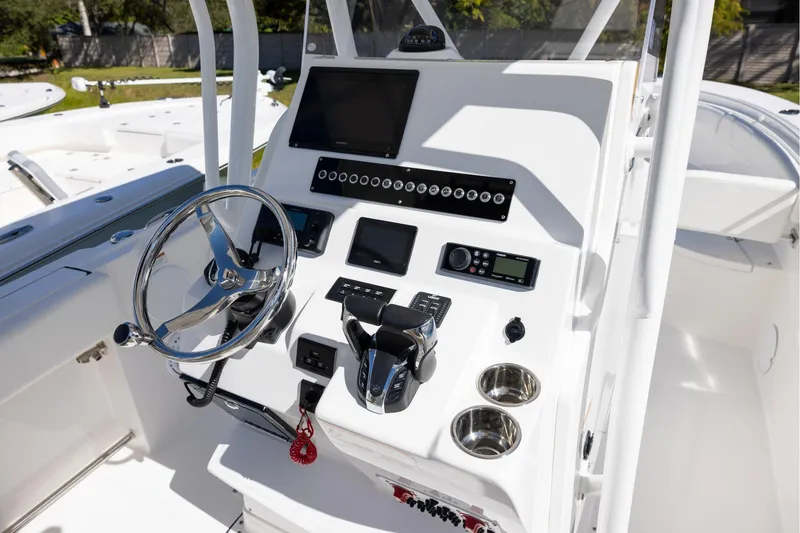 Slide: The Image of 2023 Edgewater 245CC boat console with steering wheel and electronic controls. - 7
