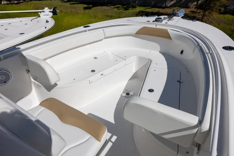 Slide: The Image of 2023 Edgewater 245CC boat interior with white seating and storage compartments. - 9