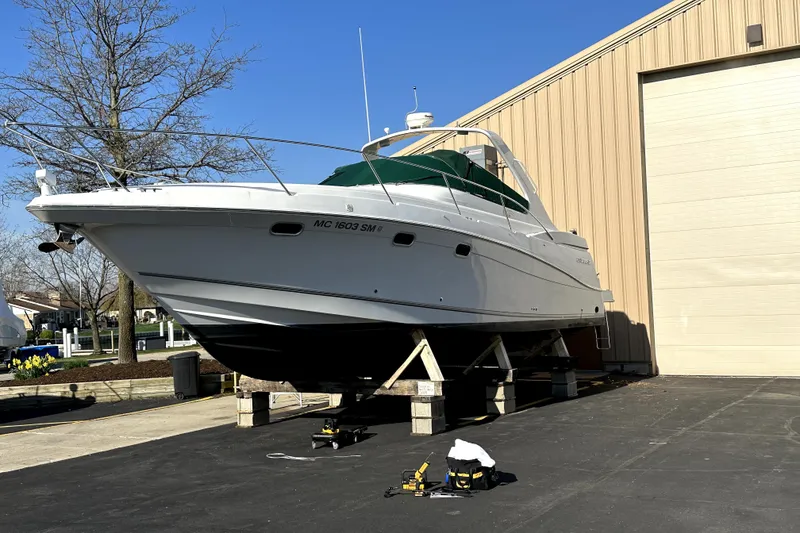 The Image of 2002 Four Winns 378 Vista boat on stands near a building, clear sky background. - 0
