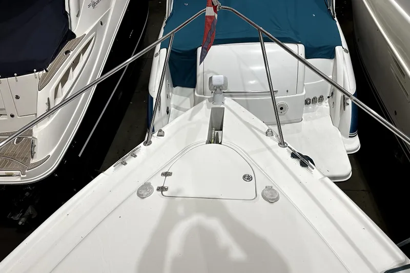 Slide: The Image of 2002 Four Winns 378 Vista boat docked, featuring a sleek white deck and blue cover. - 13