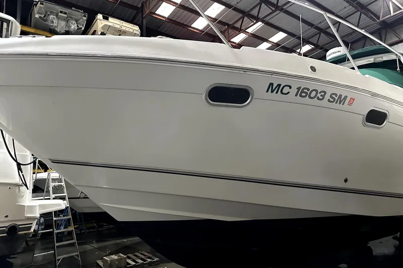 Slide: The Image of 2002 Four Winns 378 Vista boat in a warehouse, side view with registration number. - 2