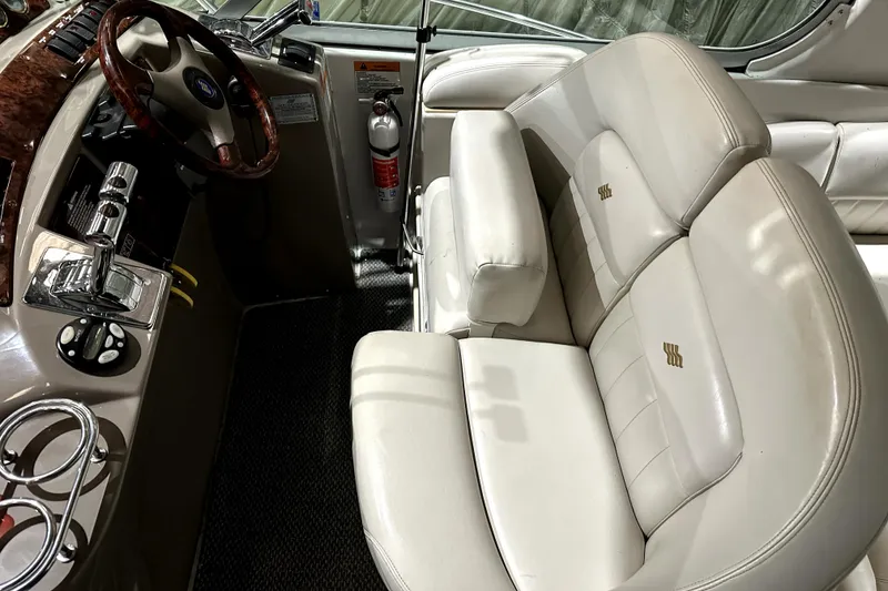 Slide: The Image of 2002 Four Winns 378 Vista boat interior with steering wheel and beige seating. - 22