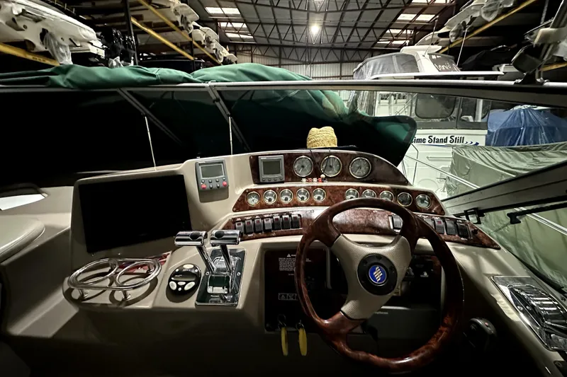 Slide: The Image of 2002 Four Winns 378 Vista boat helm with gauges and controls in storage facility. - 23