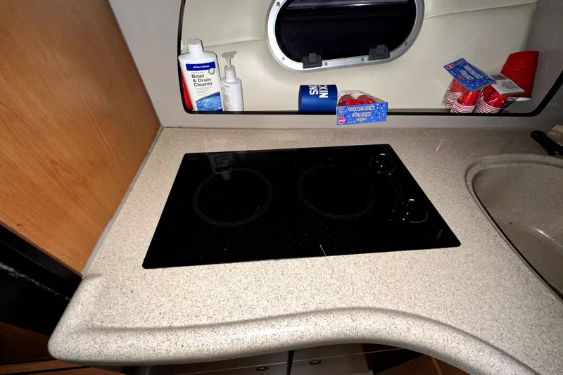 Slide: The Image of 2002 Four Winns 378 Vista kitchen with electric stove, cleaning supplies, and red cups. - 36