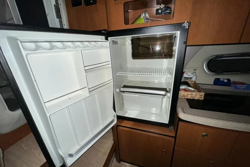 Slide: The Image of Open refrigerator inside 2002 Four Winns 378 Vista boat cabin, showcasing storage space. - 38