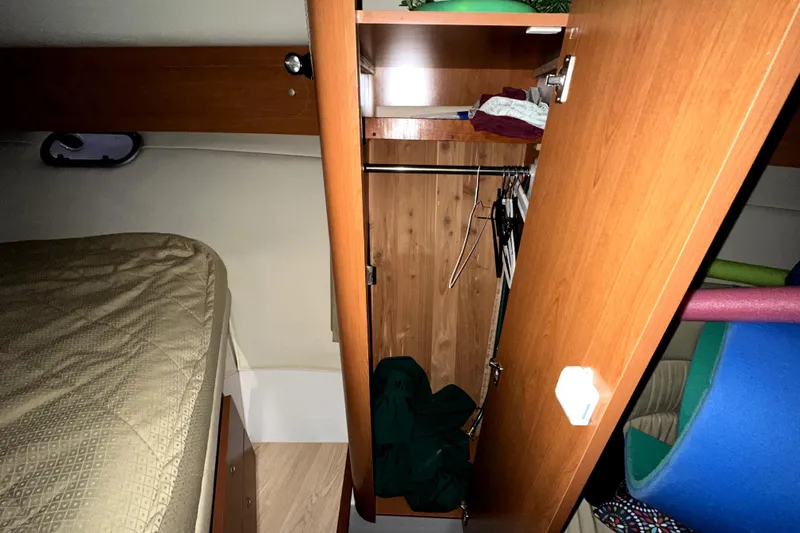 Slide: The Image of 2002 Four Winns 378 Vista cabin interior with bed and open wooden closet. - 40