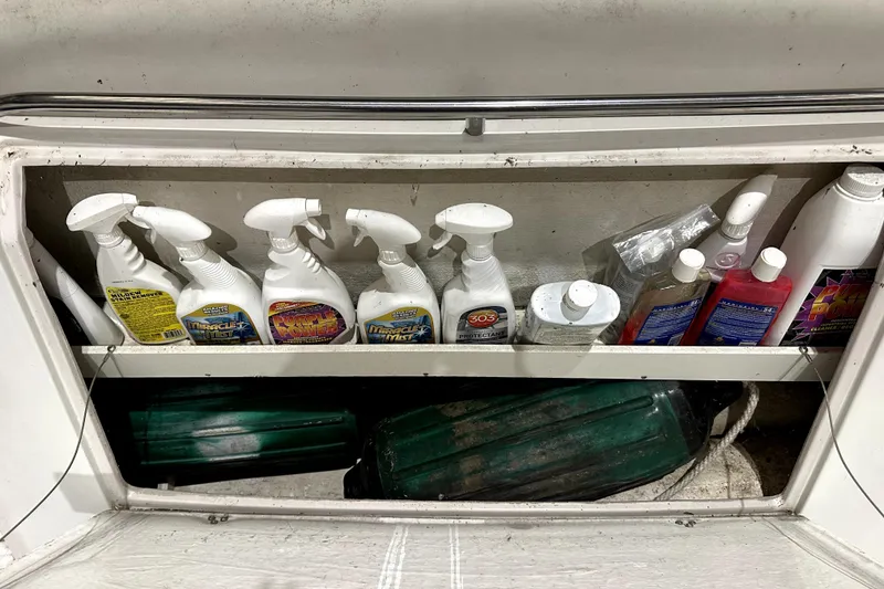 Slide: The Image of Storage compartment with cleaning supplies on a 2002 Four Winns 378 Vista boat. - 64