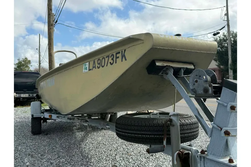 Slide: The Image of 2004 Custom BFC Marine 16 boat on trailer, parked on gravel, under cloudy sky. - 3