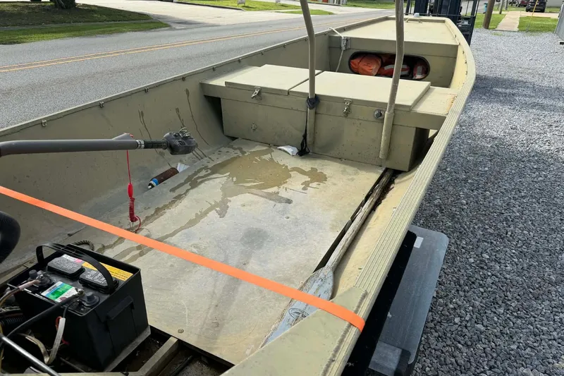 Slide: The Image of 2004 Custom BFC Marine 16 boat interior with motor and storage compartments. - 8