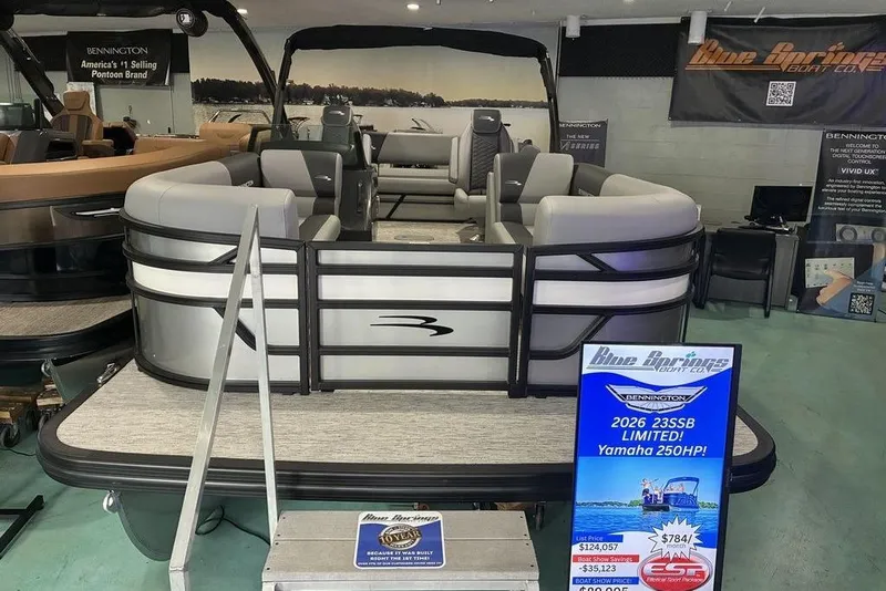 The Image of 2026 Bennington S Swingback 23 SSB pontoon boat displayed in showroom with promotional signage. - 2