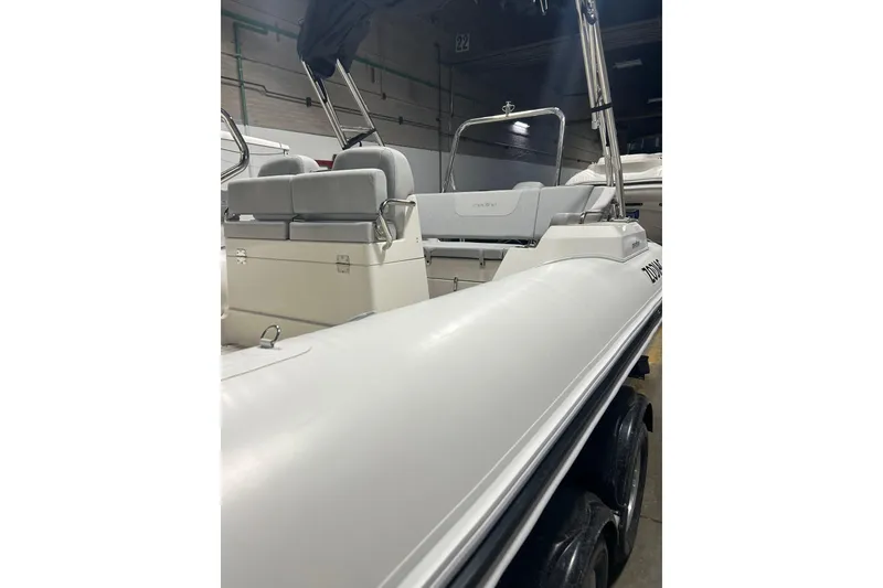 Slide: The Image of 2025 Zodiac Medline 6.8 boat cruising on open water under a clear blue sky. - 2