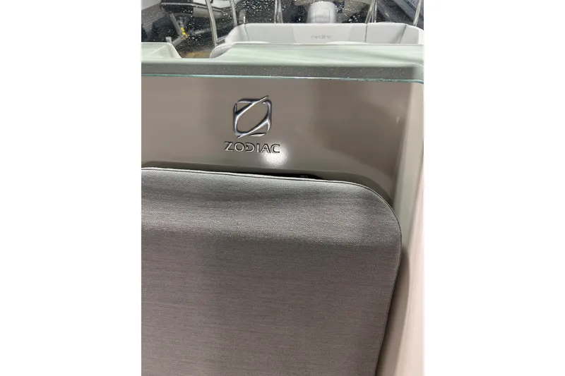 Slide: The Image of 2025 Zodiac Medline 6.8 boat interior with seating and console in a warehouse. - 7