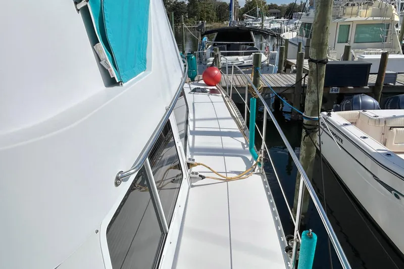Slide: The Image of 2004 PDQ 34 Power Catamaran docked, featuring a clean deck and vibrant teal accents. - 10