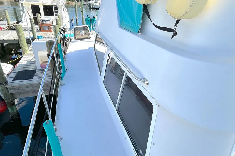 Slide: The Image of 2004 PDQ 34 Power Catamaran docked, showing side deck and railing. - 13
