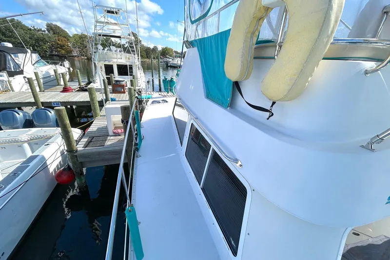 Slide: The Image of 2004 PDQ 34 Power Catamaran docked at marina with clear skies. - 14