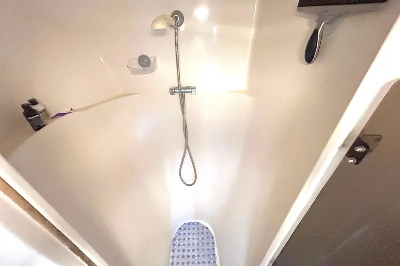 Slide: The Image of Shower area inside 2004 PDQ 34 Power Catamaran, featuring handheld showerhead and toiletries. - 44