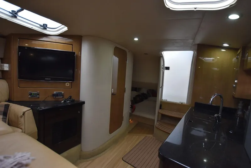 Slide: The Image of Interior of a 2011 Formula 400ss boat with TV, kitchenette, and seating area. - 16