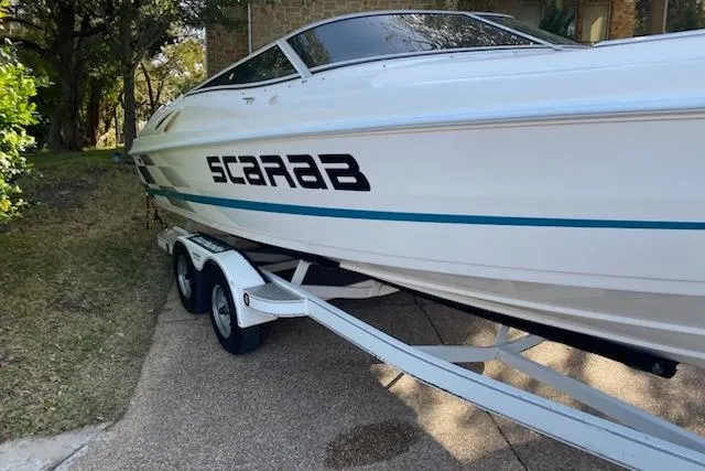 Slide: The Image of 1998 Wellcraft 26 Scarab boat on trailer, parked outdoors. - 35