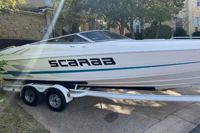 Slide: The Image of 1998 Wellcraft 26 Scarab boat on trailer, parked in residential driveway. - 38