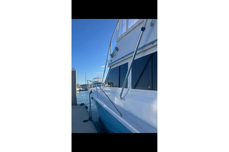 Slide: The Image of 1982 Viking 46 Convertible yacht docked at marina under clear blue sky. - 4