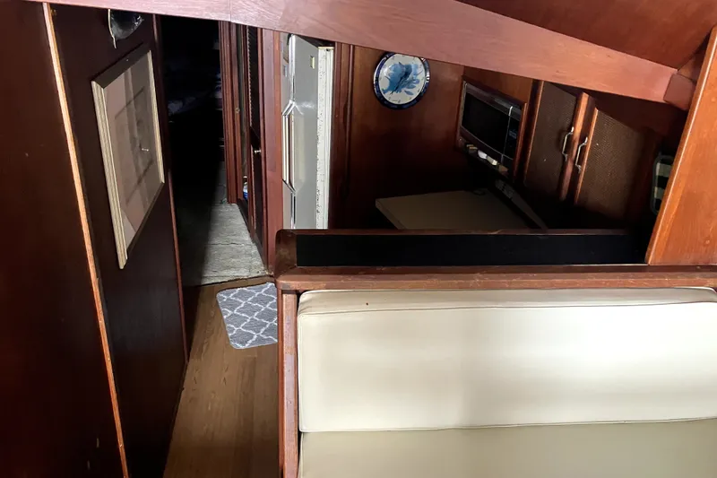 Slide: The Image of Interior of 1982 Viking 46 Convertible yacht, featuring wood paneling and compact kitchen area. - 10