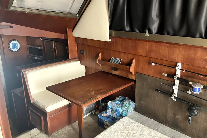 Slide: The Image of Interior of 1982 Viking 46 Convertible boat with dining area and fishing rods. - 8