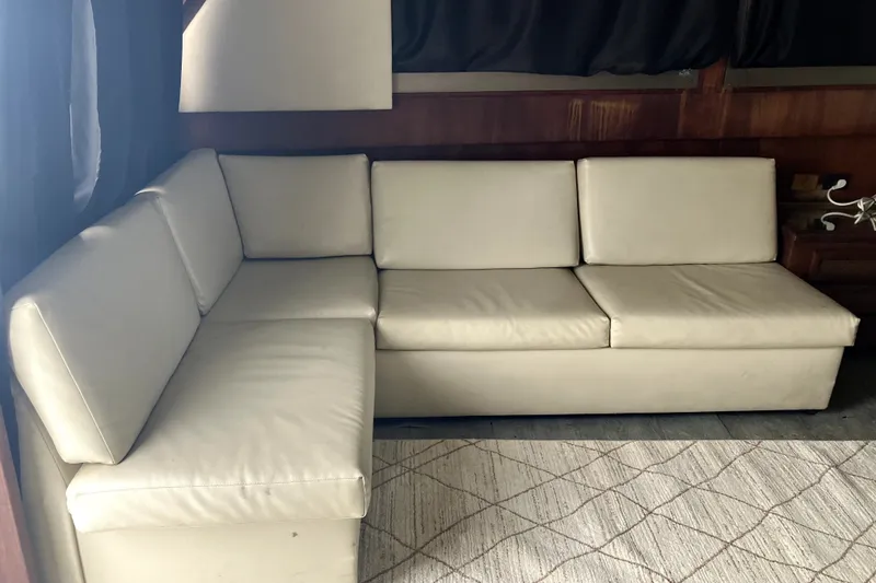Slide: The Image of Cream leather sofa inside 1982 Viking 46 Convertible yacht, with wooden interior accents. - 11