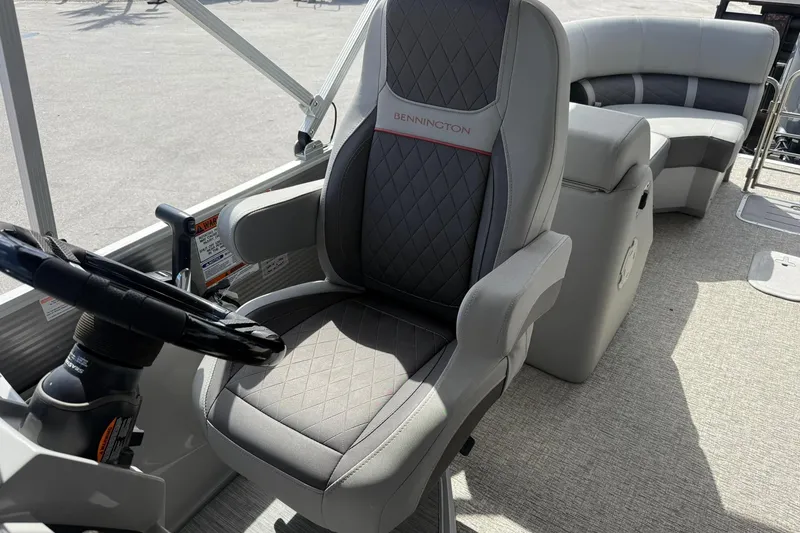 Slide: The Image of Captain's chair on 2022 Bennington 25 LFB pontoon boat, featuring luxurious seating and steering wheel. - 18