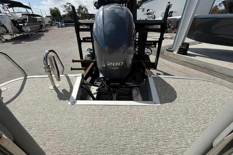 Slide: The Image of 2022 Bennington 25 LFB boat with Yamaha 200 engine at a marina. - 25