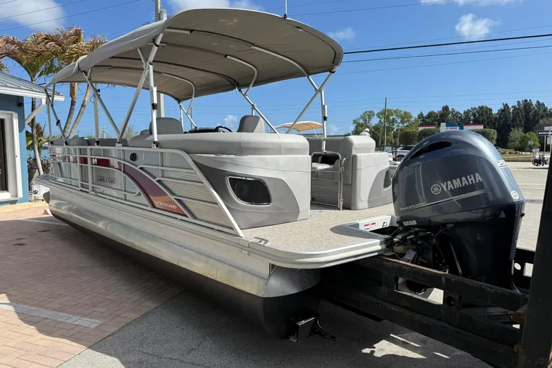 Slide: The Image of 2022 Bennington 25 LFB pontoon boat with Yamaha engine, parked outdoors. - 4