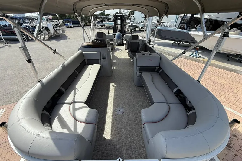 Slide: The Image of 2022 Bennington 25 LFB pontoon boat with spacious seating and canopy in a marina setting. - 8