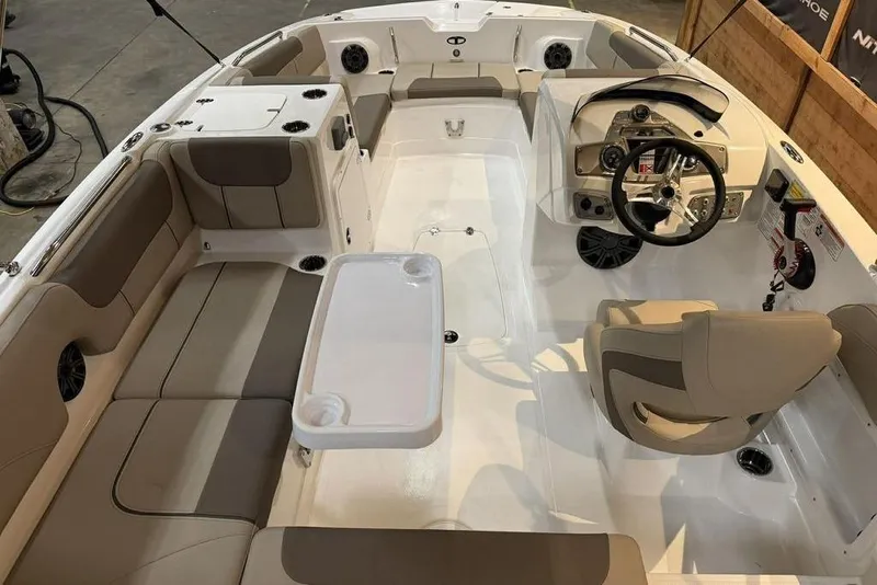 Slide: The Image of 2026 Tahoe 2150 boat interior with beige seating, steering wheel, and table setup. - 7