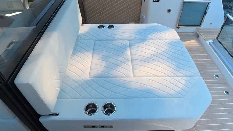 Slide: The Image of The image shows a luxurious cushioned bench on a boat, surrounded by wooden decking. - 8