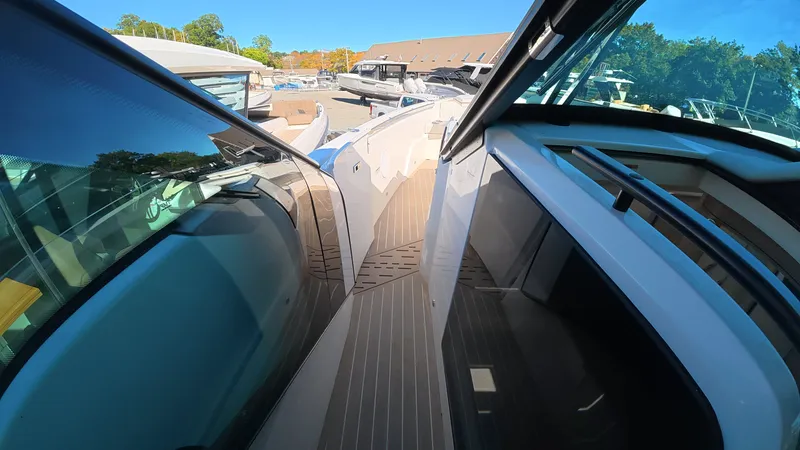 Slide: The Image of A modern boat with sleek design and spacious deck, surrounded by other boats in a marina. - 38